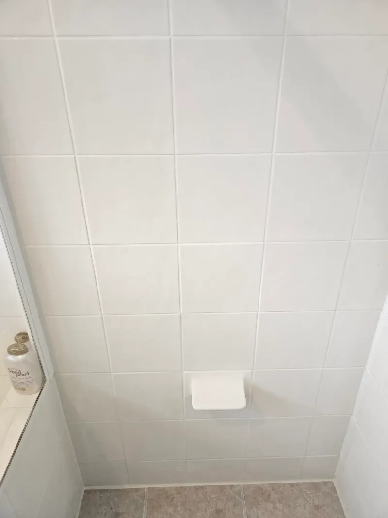 Square white tiles across a shower wall
