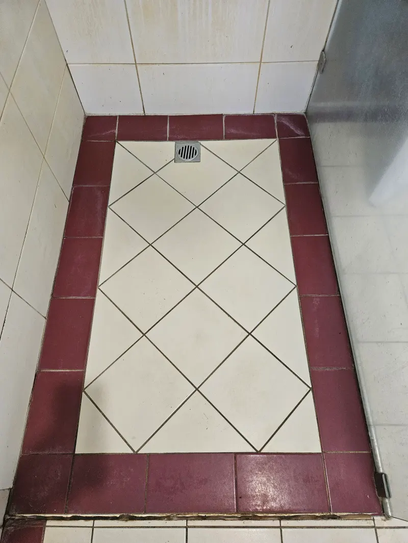 White shower floor framed by red border tiles