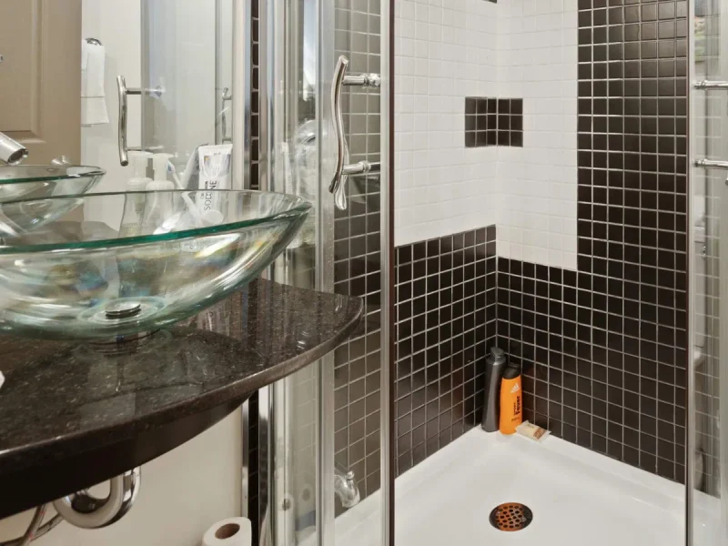 Dark vanity beside a tiled glass shower