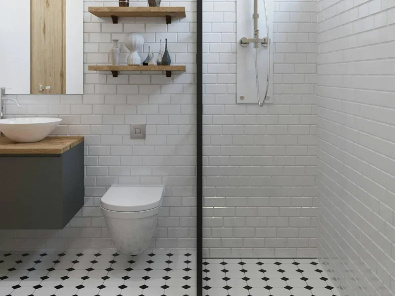 White tiled shower with a dark mosaic floor