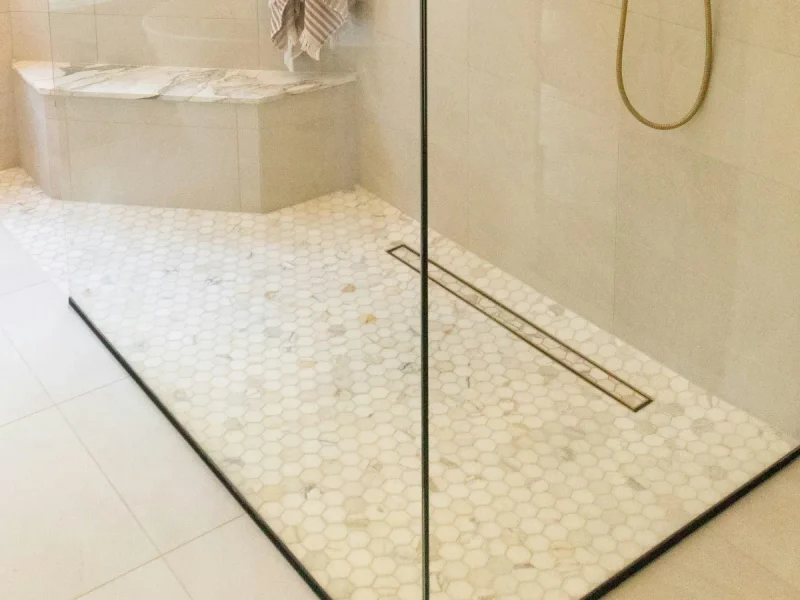White mosaic shower floor with a linear drain