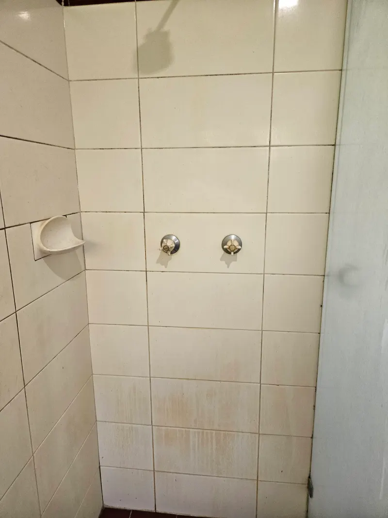 Shower tap fittings on white tiles