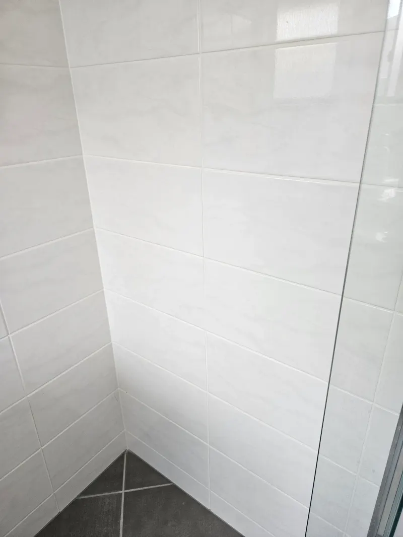 Upper tiled shower wall and ceiling junction