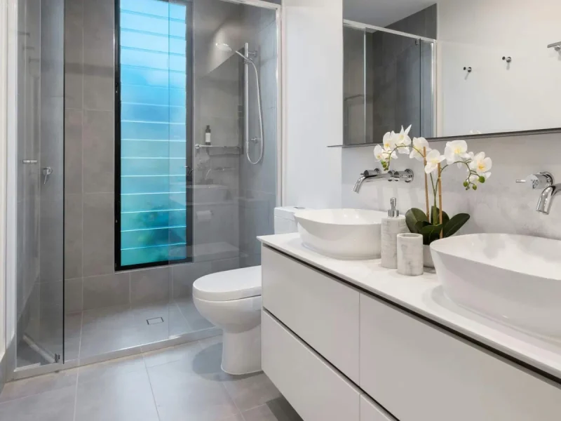 Modern bathroom with a blue feature wall and glass shower