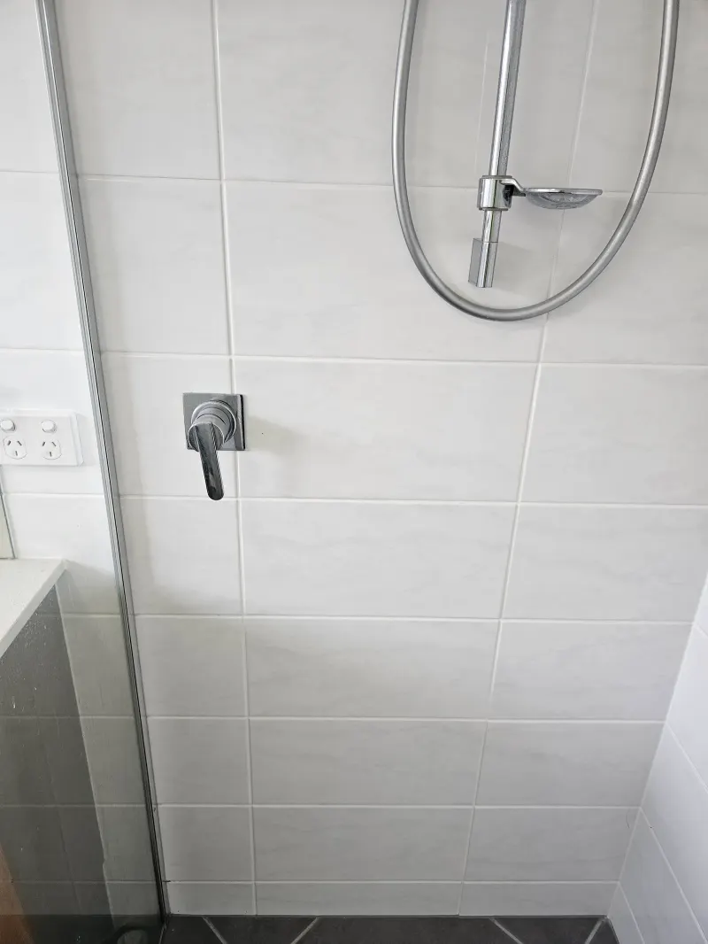 Shower mixer and fittings on a tiled wall