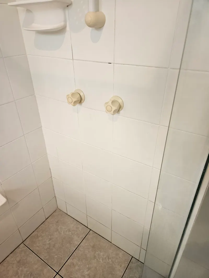 Showerhead and fittings on a white tiled wall