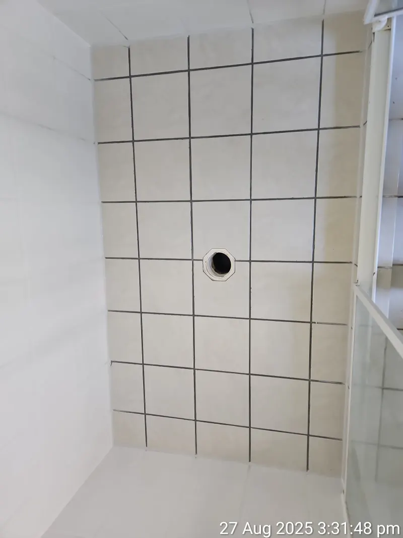 Light square-tiled shower floor and drain