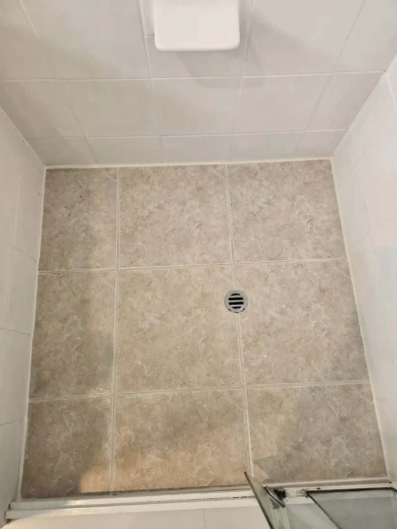 Worn grout between shower floor tiles